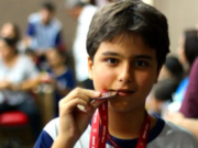 menino campeão em matemática com medalha na boca